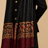 A black textured shawl scarf with ornate red, gold, and beige floral borders and red striped lower ends, shown worn over a black button-front coat on a model. The collage includes three views: a front view, a close-up of the border, and a draped styling view.
