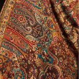 A collage showing a woman wearing a large, ornate paisley shawl in an indoor setting. The main panel shows the shawl draped over her shoulders, while the right-side panels are close-up detail views of the fabric pattern.