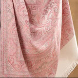 Person wearing a pink patterned shawl on a beige background