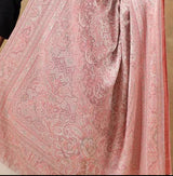 Person wearing a pink patterned scarf against a beige background