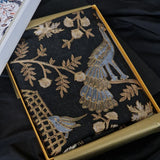 Embroidered fabric with floral patterns in a gold frame on a dark background